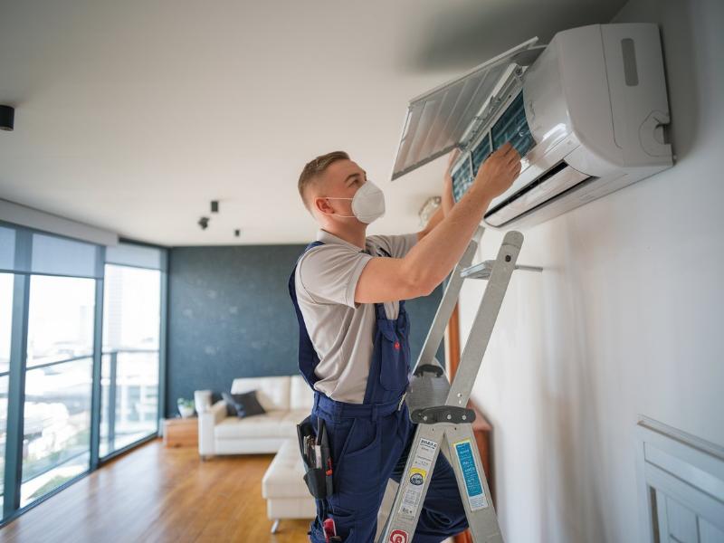 specjalista montujący klimatyzację w mieszkaniu